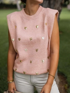 Débardeur en maille rose avec cœurs à paillettes dorées et épaulettes sur gazon