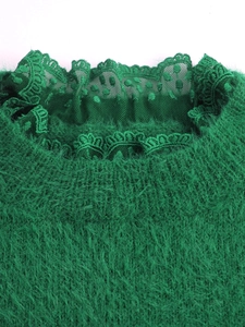Détail du pull en maille verte montrant l'encolure en dentelle et la texture douce