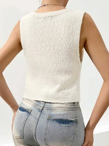 Vista posteriore di un gilet in maglia bianca da donna con trama a costine verticali