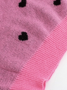 Pink knit sweater with black heart patterns and ribbed texture for a cozy look