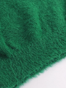 Gros plan sur un tricot vert émeraude aux textures de peluche à poils longs et doux