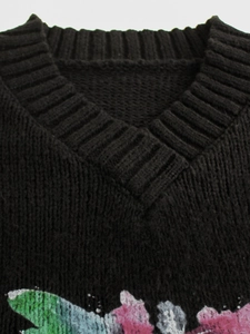 Detailed close-up of V-neckline and rib knit texture on black long sleeve sweater