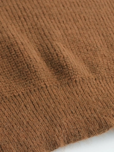 Close-up of brown knit fabric showing the soft fuzzy texture and ribbed knit craftsmanship