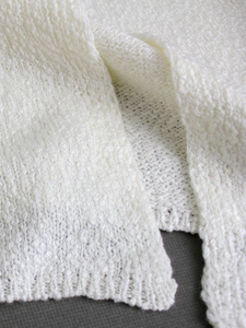 Trama in maglia dettagliata del gilet cardigan bianco senza maniche in morbido cotone