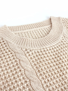 Short-sleeved cream knit sweater featuring cable knit patterns and round neckline
