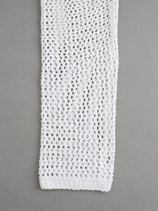 Détail du cardigan de plage en maille blanche montrant le motif ajouré et le bord côtelé