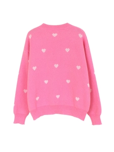 Detail view of the soft ribbed texture and white heart pattern on this pink knit sweater