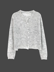 Detail eines hellgrauen Mohair-Cardigans mit weißen Knöpfen und weicher Strickstruktur