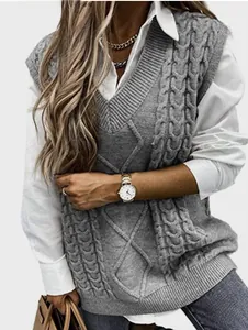 Detail of grey cable-knit V-neck vest showing intricate diamond and twist texture