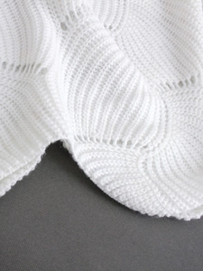 Women's white knitted pullover sweater featuring decorative scalloped edges and ribbed texture