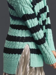 Detail of cable knit texture and side split hem on mint green striped sweater