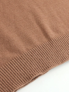 Gros plan sur la texture d'un pull en maille marron avec détail de l'ourlet côtelé