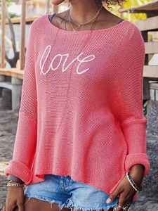 Detail of coral pink open knit sweater with white love script and rolled cuffs