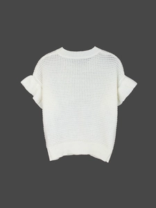 Close-up of white hollow-out knit sweater showing ruffle cuffs and round neckline details