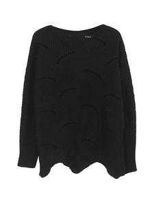 Detail view of black knit sweater featuring scalloped hem and pointelle wave patterns