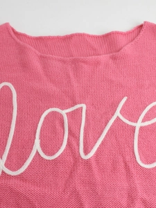 Pink knit sweater with long sleeves featuring a white Love script embroidery on the front