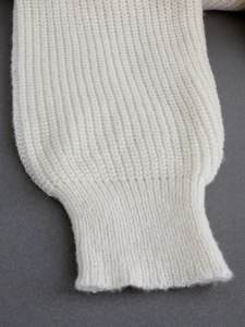 White V-neck knitted sweater dress featuring elegant ribbed cuffs and soft wool texture