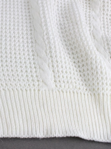 Macro detail of cable knit patterns and honeycomb hollow textures on white sweater fabric