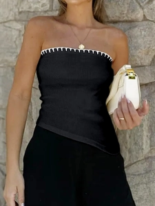 Detail of black knit tube top with white scalloped trim and asymmetrical hem design