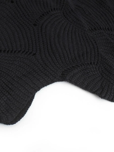 Detailed macro view of black knit sweater featuring unique wavy texture and micro-hole pattern