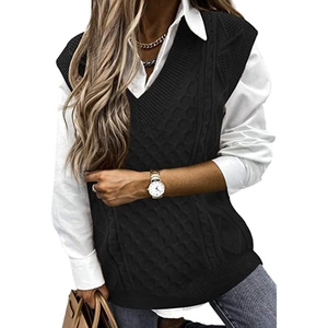 Oversized black V-neck cable-knit sweater vest layered over a white shirt for women