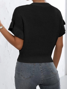 Macro detail of black waffle knit texture and ribbed hem on a women's short sleeve sweater