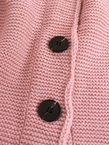 Detail of pink hollow-out knit cardigan with textured chunky knit and dark marble buttons