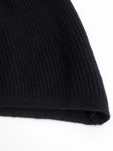 Close-up of black ribbed knit fabric texture showing detail of the premium soft material