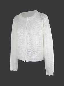 Detail der weißen Häkelstrickjacke mit filigranen Lochmustern und runden Knöpfen