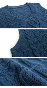 Detailed macro view of navy blue cable knit texture and V-neckline of a knit sweater vest