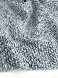 Grey knitted long sleeve pullover sweater featuring soft ribbed hem and fine wool texture