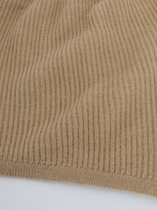 Macro shot of khaki ribbed knit fabric showing soft texture and detailed wool-blend fibers