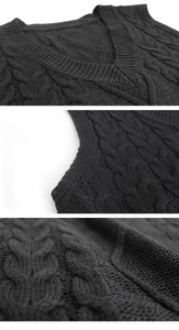 Macro detail of V-neckline and cable knit texture on a black sleeveless sweater vest