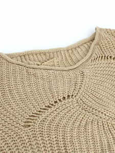 Close-up of ribbed crew neck and decorative hollow knit pattern on khaki sweater