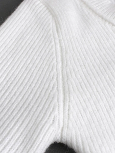 Macro detail of high-quality white ribbed knit fabric texture and seamless stitching