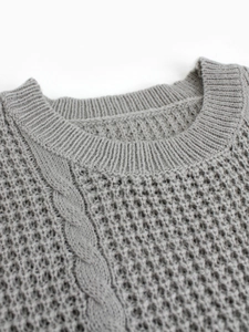 Close-up of grey short-sleeved sweater featuring round neck and intricate cable knit texture