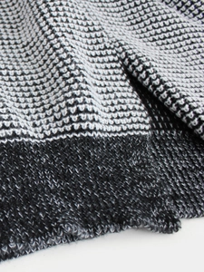 Detailed macro shot of high-quality tricolor waffle knit fabric in black, white, and grey