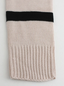 Women's long knit cardigan featuring beige and black striped cuffs with ribbed texture