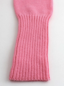 Dettaglio ravvicinato della manica del cardigan in maglia rosa con polsino a coste