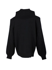 Detailed view of black cable-knit sweater sleeves and unique cold-shoulder neckline