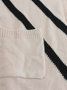 Close-up of knit fabric pocket with black diagonal stripes and ribbed trim details