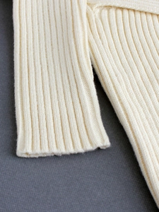 Creamy white V-neck rib-knit sweater dress showing detailed fiber texture and elasticity