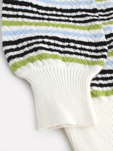 Détail de la manche d'un pull rayé coloré avec poignet élastique blanc côtelé