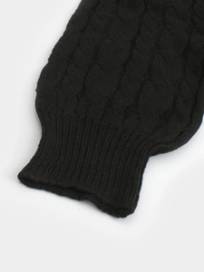 Close-up of black cable knit sweater sleeve with elastic ribbed cuffs for autumn winter