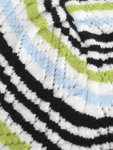 Détail du tissu en maille au crochet avec des rayures colorées noir, blanc, bleu et vert