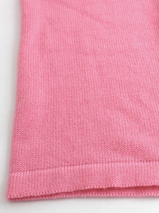 Dettaglio macro del tessuto a maglia rosa con trama fine e finitura a coste