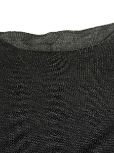 Detail view of the fine knit texture and neckline seam on this black long sleeve sweater