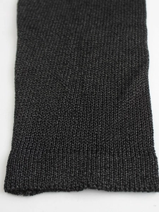 Close-up of the black knitted fabric texture with fine ribbing detail and elastic weave