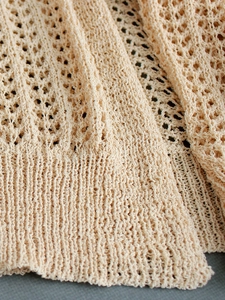 Beige crochet knit cardigan featuring delicate pointelle hollow patterns and ribbed cuffs