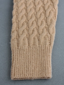 Close-up of khaki cable knit cardigan sleeve with premium wool texture and ribbed cuff